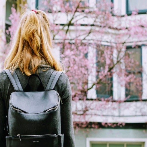 Picture of back of girl with a backpack looking at a university campus building